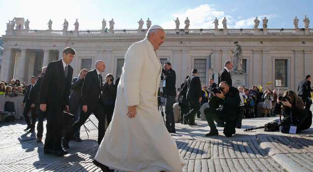 Pope Francis walks as he arrives to lead the weekly audience in Saint Peter's Square.