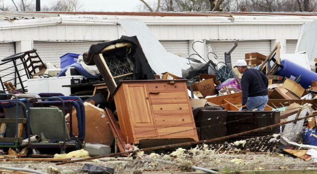 A man rifles through his damaged home after tornadoes ripped through Texas.