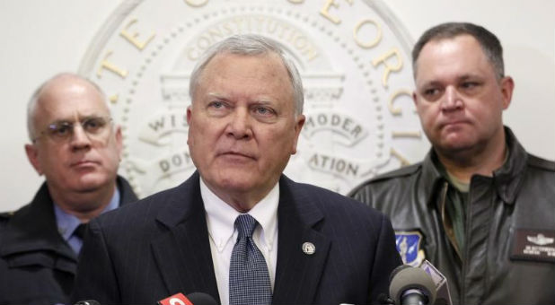 Georgia Governor Nathan Deal (C), speaks to the media as Public Safety Director Mark McDonough (L), and Georgia National Guard Director General Jim Butterworth listen at the State Capitol in Atlanta.