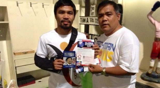 Boxer Manny Pacquiao, left, with a Global Outreach Day tract