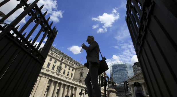 Pedestrians walk past the Bank of England in the City of London