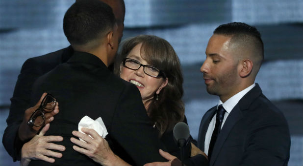 Christine Leinonen, whose son was killed in the Pulse attack in Orlando, is embraced by attack survivors Brandon Wolf (L) and Jose Arraigada (R) on the third day of the Democratic National Convention in Philadelphia