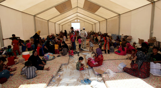 Displaced Iraqi people, who fled from Qayyara because of Islamic State violence, gather at a refugee camp