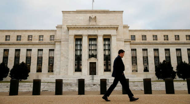 A man walks past the Federal Reserve Bank in Washington, D.C.