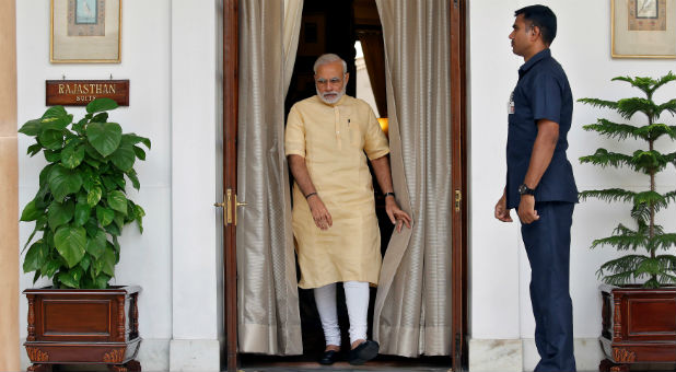 India's PM Narendra Modi makes his way to greet Afghan President Ashraf Ghani inside Hyderabad House in Delhi