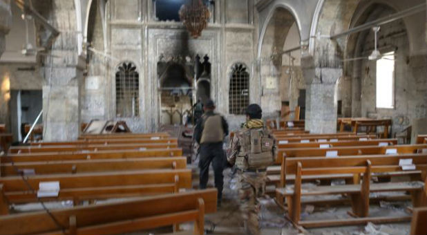 Iraqi special forces soldiers walk inside a church damaged by Islamic States fighters in Bartella, east of Mosul, Iraq