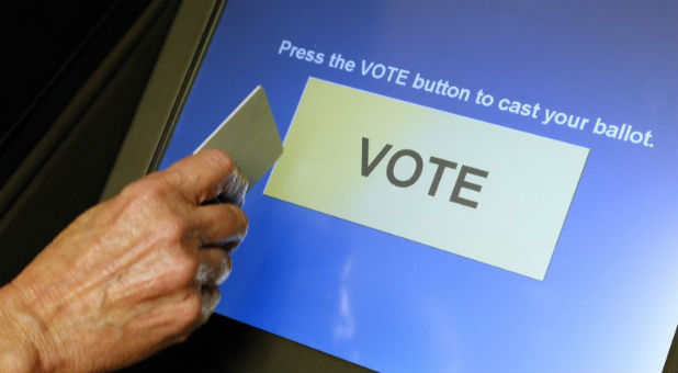 An elections official demonstrates a touch-screen voting machine at the Fairfax County Governmental Center in Fairfax, Virginia