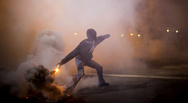 A protester throws a can of smoke during a riot in Baltimore.