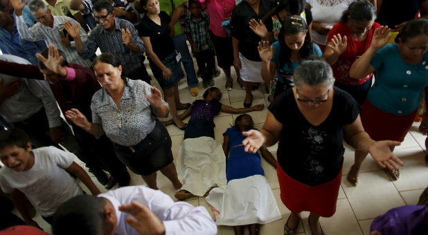 People pray during a mass in an evangelical church in the village of Rio Pardo next to Bom Futuro National Forest, in the district of Porto Velho, Rondonia State, Brazil