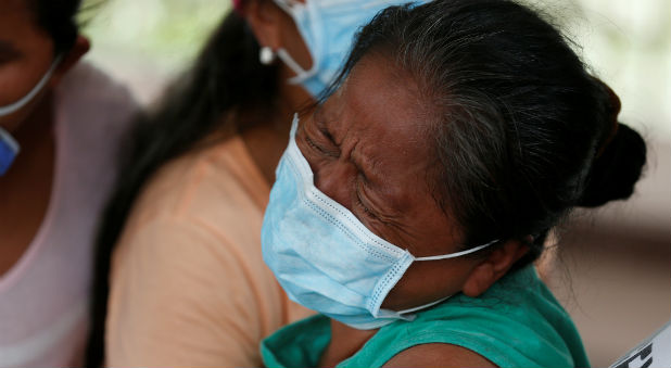 A woman cries as she identifies her daughter's body after flooding and mudslides caused by heavy rains in Villagarzon, Colombia
