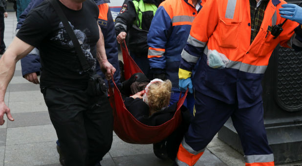 An injured person is helped by emergency services outside Sennaya Ploshchad metro station, following explosions in two train carriages at metro stations in St. Petersburg