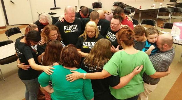 A group of REBOOT members pray together.