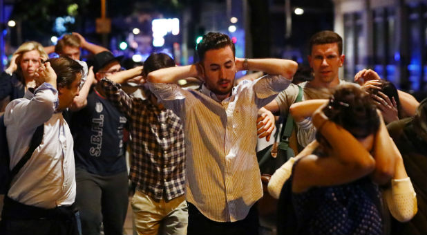 People leave the area with their hands up after an incident near London Bridge.