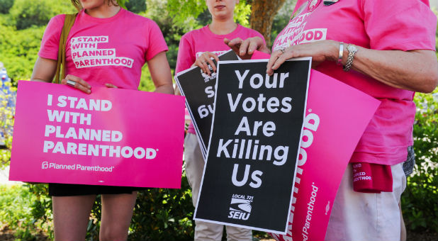 Supporters of Planned Parenthood hold signs during a rally to fight back against the U.S. House of Representatives' vote to repeal the Affordable Care Act held outside of the office of Congressman Steve Knight in Santa Clarita, Los Angeles, California.