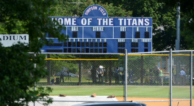 Investigators under a scoreboard search for clues at the scene where shots were fired during a congressional baseball practice, wounding House Majority Whip Steve Scalise, R-La., Alexandria, Virginia.