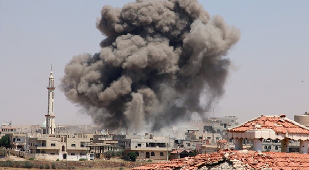 Smoke rises after airstrikes on a rebel-held part of the southern city of Deraa, Syria.