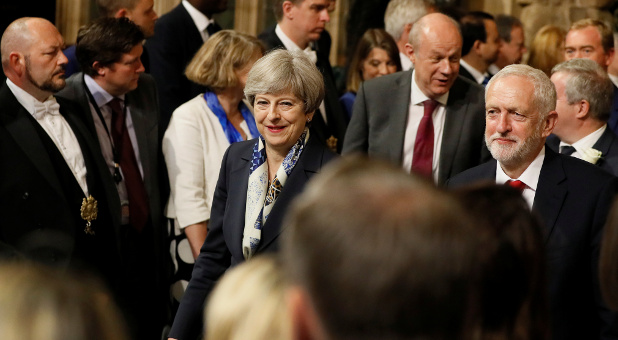 Britain's Prime Minister, Theresa May, and opposition Labour Party leader, Jeremy Corbyn, walk through the Peers Lobby in the Houses of Parliament during the State Opening of Parliament in central London, Britain.