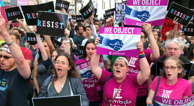 Crowds of people protest President Donald Trump's announcement that he plans to reinstate a ban on transgender individuals from serving in any capacity in the U.S. military, in Times Square, New York.