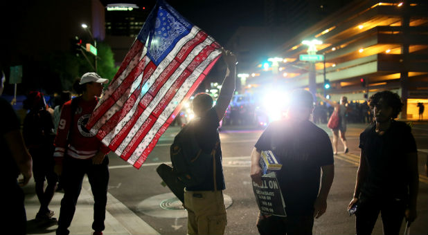 A demonstrator holds an American flag.