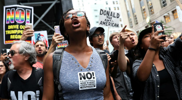 Anti-racism protesters shout during protests in front of Trump Tower.