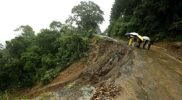 Residents look at road partially collapsed by heavy rains of Tropical Storm Nate that affects the country in El Llano de Alajuelita, Costa Rica.