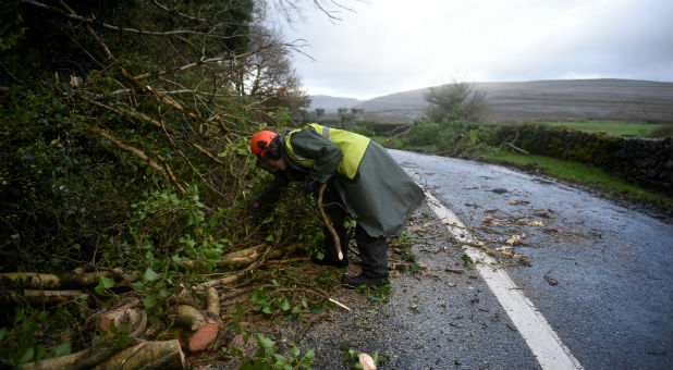 A worker clears fallen trees off a road during Storm Ophelia.
