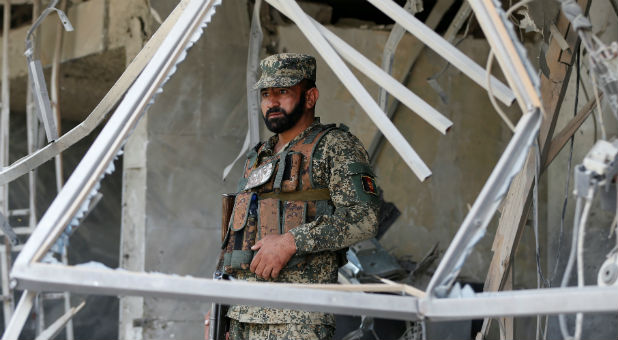 An Afghan security force member stands guard at the site of a suicide bomb attack in Kabul, Afghanistan.