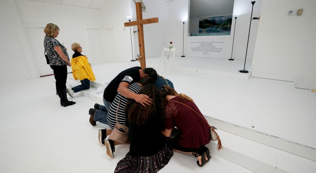 People pray in the First Baptist Church of Sutherland Springs where 26 people were killed in a shooting attack last week, as the church was opened to the public as a memorial to those killed.