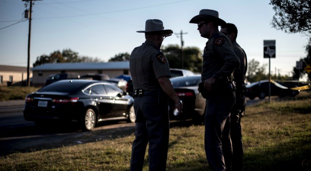 Members of the Wilson County Sheriff's office stand just inside taped off area near the First Baptist Church where a shooting left many dead and injured in Sutherland Springs, Texas.