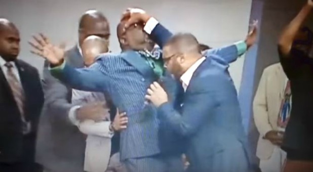 Tyler Perry prays over T.D. Jakes.