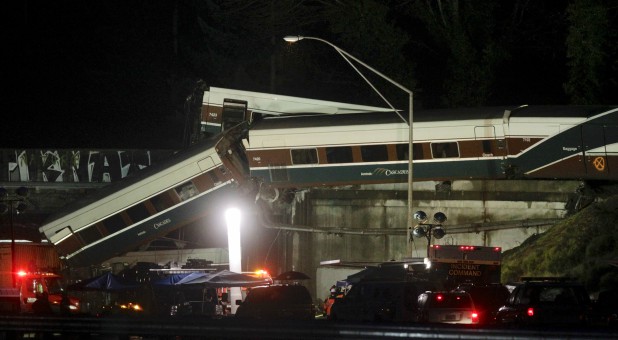 Rescue personnel and equipment are seen working into darkness at the scene where an Amtrak passenger train derailed.
