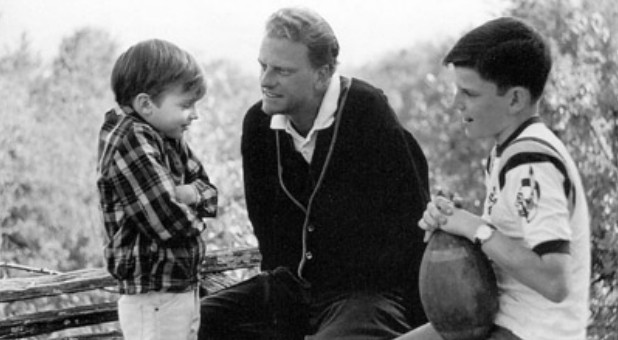 Billy Graham tried to save the world, traveling for months at a time to more than 170 countries to preach the gospel to tens of millions. In a rare moment at home in 1965, he spends time with sons Ned, left, and Franklin.