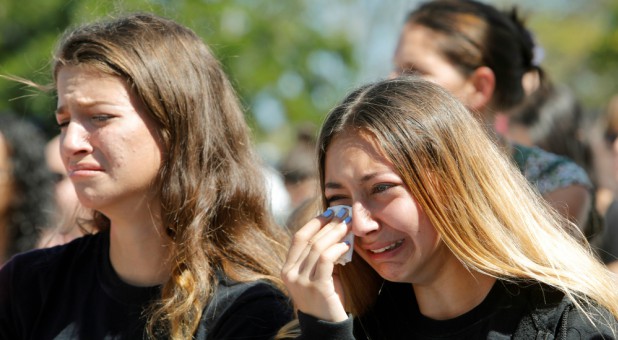 Students mourn during a community prayer vigil for victims of yesterday's shooting at nearby Marjory Stoneman Douglas High School in Parkland, at Parkridge Church in Pompano Beach, Florida.