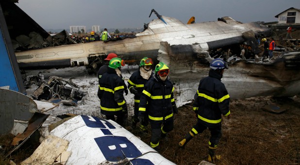 Rescue workers work at the wreckage of a US-Bangla airplane after it crashed at the Tribhuvan International Airport in Kathmandu, Nepal.