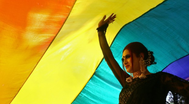 A participant walks under a rainbow flag during a gay pride parade promoting lesbian, gay, bisexual and transgender rights.