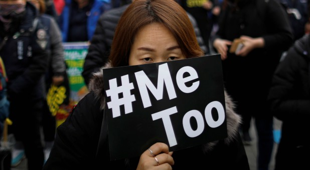 People attend a protest as a part of the #MeToo movement.