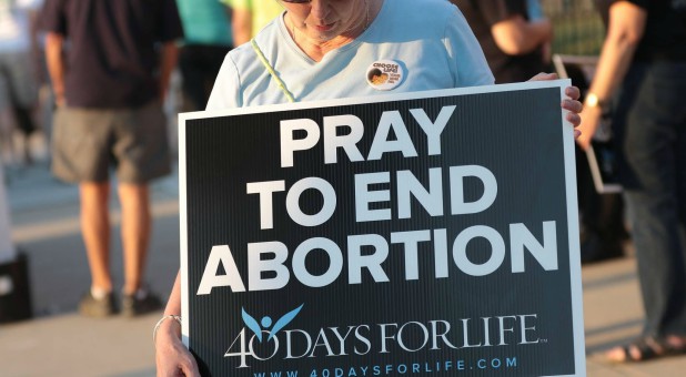 A woman prays to end abortion.