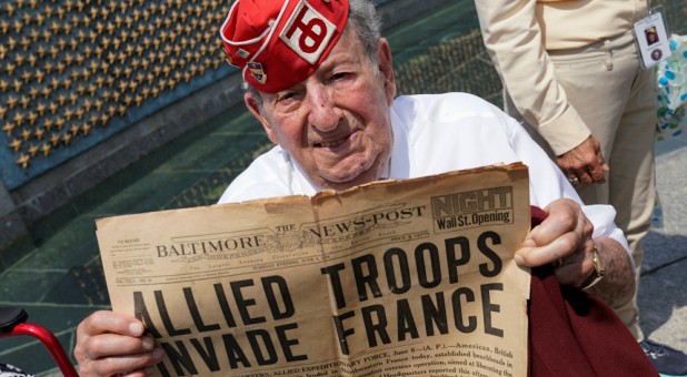D-Day veteran and former POW Robert Levine, 94, of Teaneck, New Jersey, holds up a newspaper front page during the 75th anniversary of the D-Day landings in Normandy at the World War II Memorial in Washington.