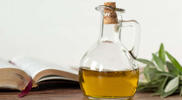 Anointing oil with a Bible and olive branch.