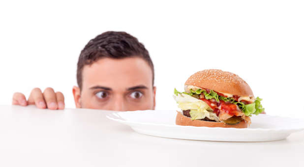 A hungry man eyeing a burger.