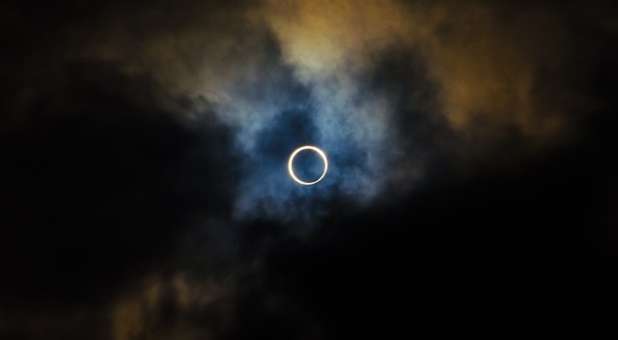 solar eclipse amid clouds